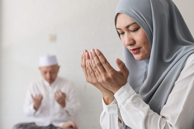Muslim woman is sitting and dua with rising hands