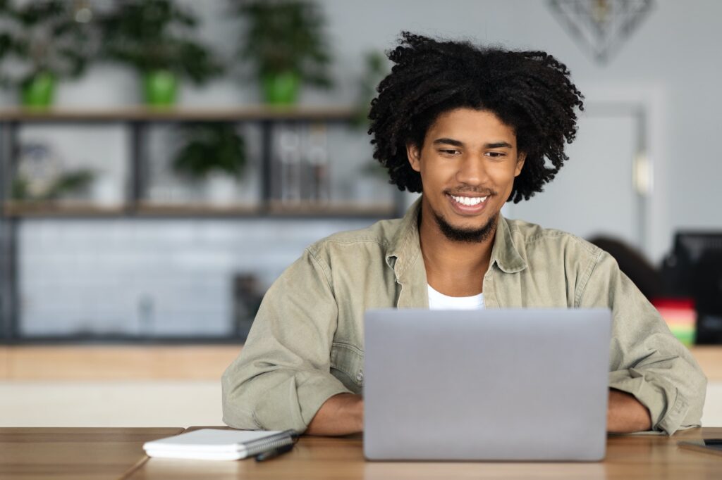 Online Education. Young Black Guy Study With Laptop While Sitting In Cafe